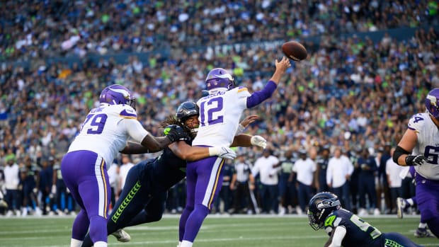 Aug 10, 2023; Seattle, Washington, USA; Seattle Seahawks defensive end Mike Morris (94) hits Minnesota Vikings quarterback Nick Mullens (12) while passing the ball during the first half at Lumen Field. Mandatory Credit: Steven Bisig-USA TODAY Sports